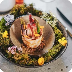 A fine-dining course plated with edible flowers