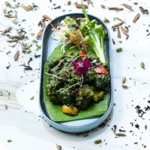A green salad course plated in a shallow dish