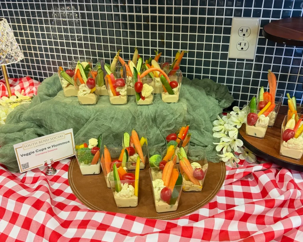 Vegetable cups with dip on a red gingham cloth