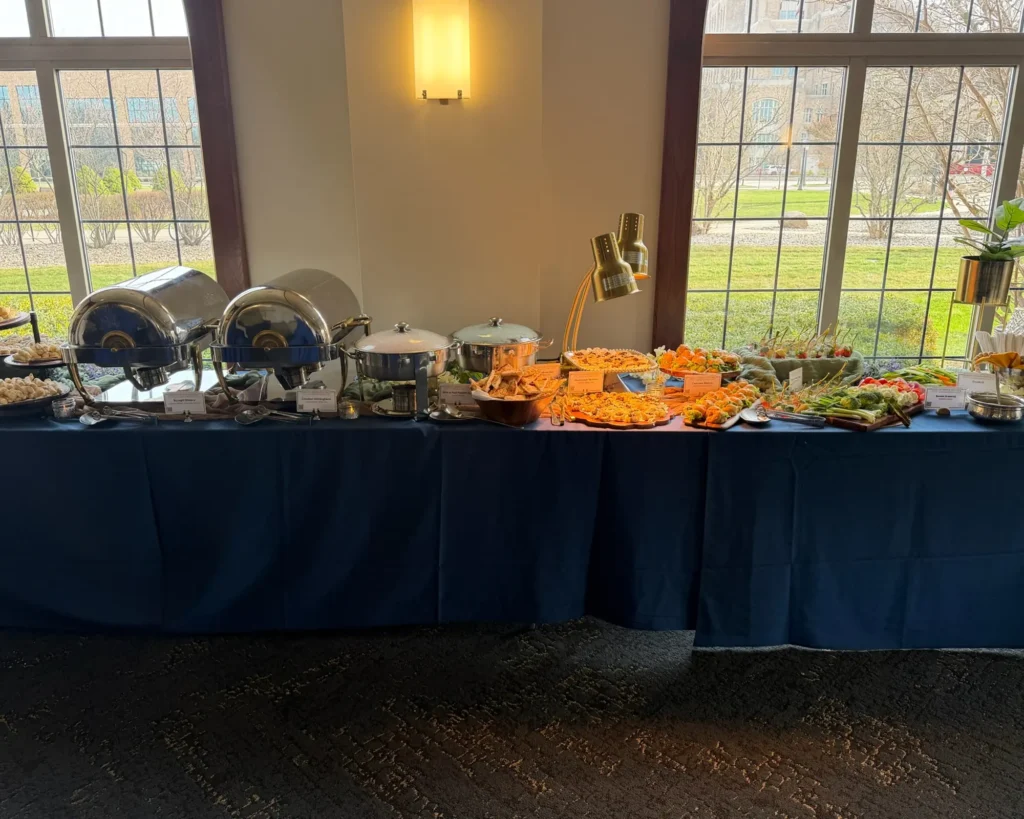 Buffet on a navy linen table beside tall windows