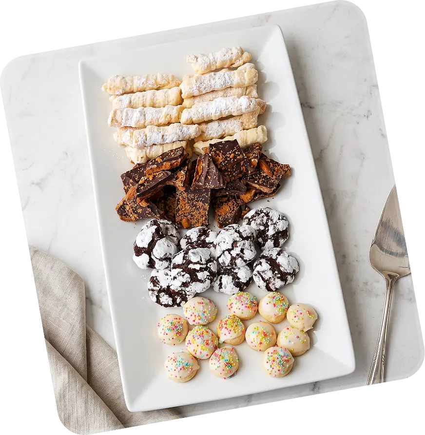 Dessert platter of cannoli, brownies and cookies on a white tray