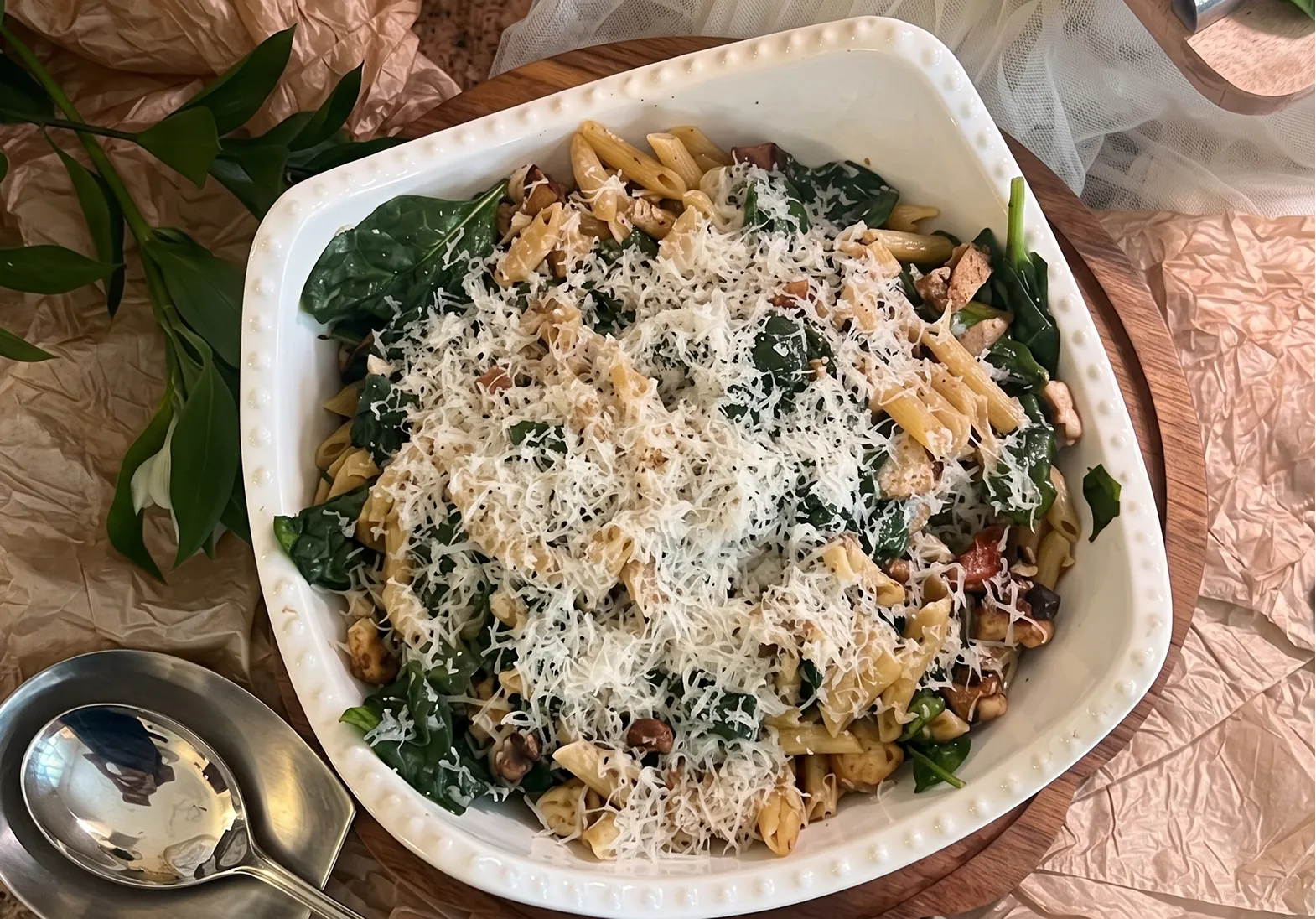 Baked pasta with spinach and parmesan, served in the dish