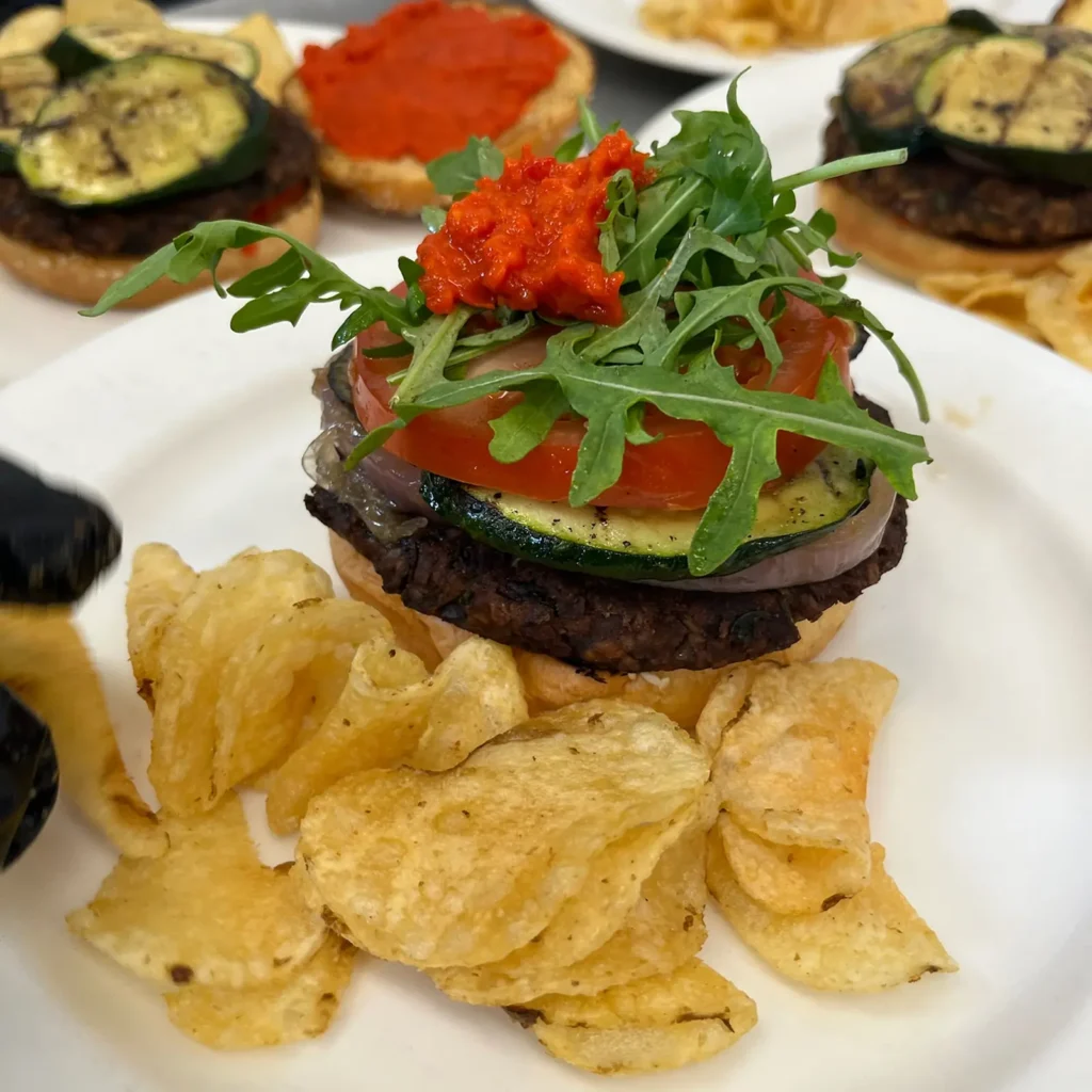 Burger with arugula and roasted tomato, served with crisps